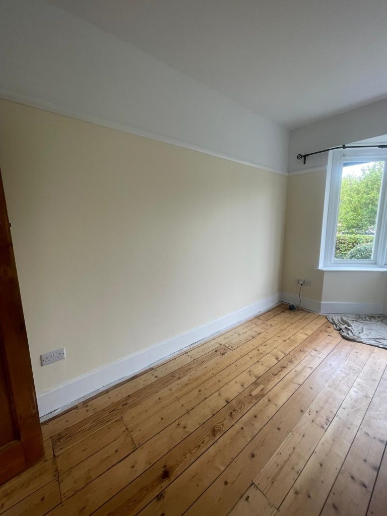 Bedroom wall painting in BS6 Bristol with clean finish around bay window and wooden floor